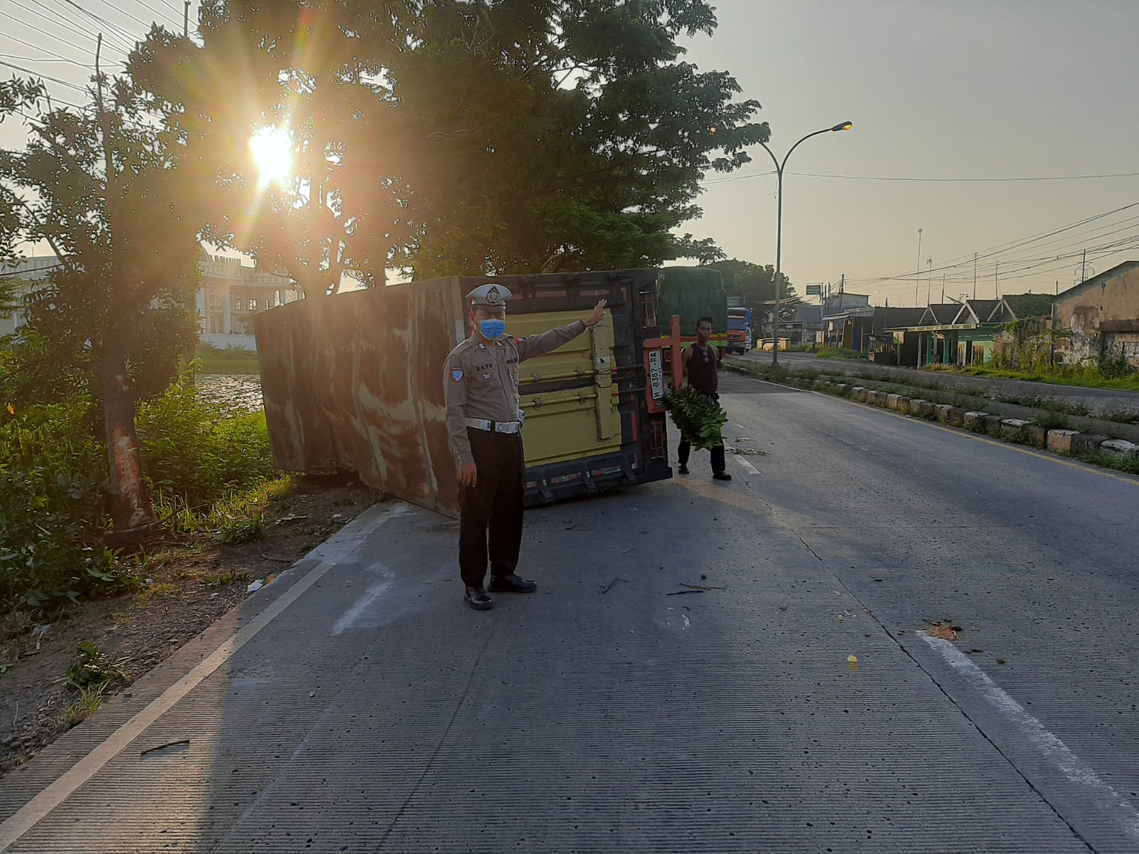 Anggota Polsek Babat Sigap Evakuasi Truk Box Terguling di Jalan Raya Babat-Lamongan