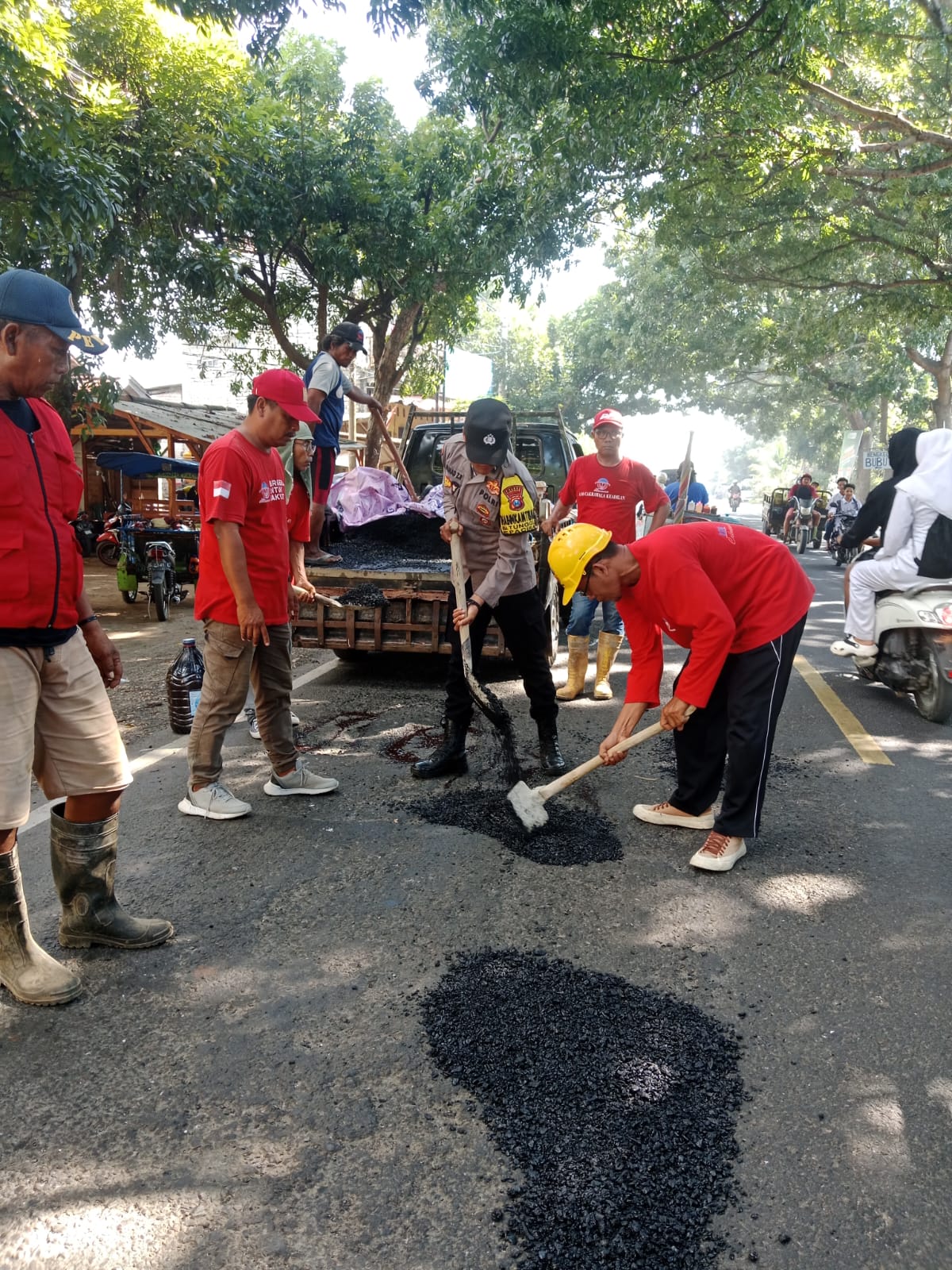 Bhabinkamtibmas Polsek Paciran Bersama LSM Cakrawala Keadilan Tambal Jalan Berlubang di Jalur Daendels